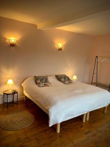 a bed in a room with two lights on the wall at Le Domaine du Castel in Saulzoir
