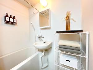 a white bathroom with a sink and a mirror at Asakusa 2 Double Beds Apt, Free WiFi in Tokyo