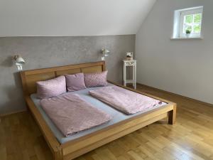 una cama con almohadas rosas en una habitación en Ferienwohnung mit Giebelzimmer, en Ravensburg