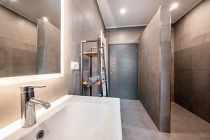 a bathroom with a white sink and a shower at Ferienhaus am See mit Sauna in Barßel +30 photos