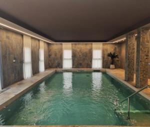 an indoor pool with green water in a room at DOMITYS - Les Vantelles in Plombières-lès-Dijon