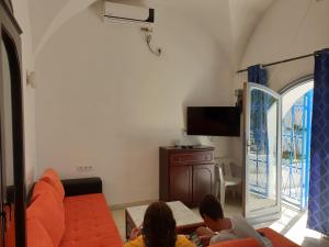 a group of people sitting in a living room with a tv at Chelly Bungalow en bord de mer in Nabeul