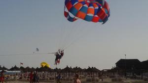 a person is falling off of a parachute on the beach at Chelly Bungalow en bord de mer in Nabeul