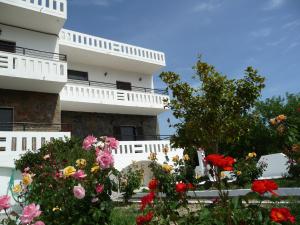 a building with flowers in front of it at Zourpos Studios & Apartments in Kalyves