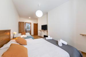 a bedroom with two beds and a flat screen tv at La Casa de la Buhardilla in Fondón