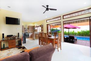 a living room with a table and a dining room at Mahabrahma Villa in Uluwatu