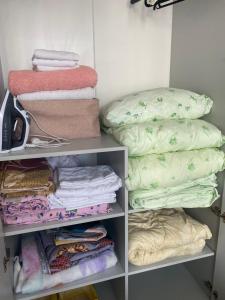 a walk in closet with towels and blankets at Sat City block A in Astana