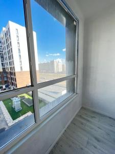 an empty room with a window with a view at Sat City block A in Astana