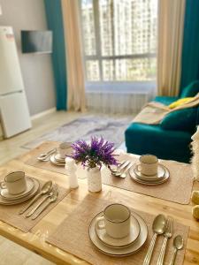 a coffee table with plates and utensils on it at Sat City block A in Astana