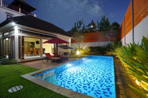 a swimming pool in the backyard of a house at night at Mahabrahma Villa in Uluwatu