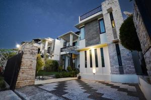 a large white house with a driveway at night at Mahabrahma Villa in Uluwatu