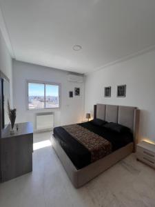 a bedroom with a large bed and a window at Happiness Apartment in Tunis