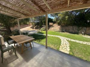 a patio with a table and chairs under a pergola at Agreen Country House in Olbia +40 photos