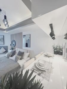 a white living room with a couch and a table at Soleil La Vie at Azure North Resort Residences in Lagundi