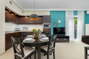 a kitchen and dining room with a table and chairs at Family Apartment with Air Conditioning in Mielno by Noclegi Renters in Mielno
