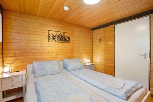a bedroom with two beds and wooden walls at Ferienhaus 10 Rechbergblick in Bernau im Schwarzwald