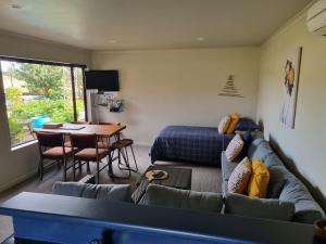 a living room with a couch and a table at 2 bedroom Apartment@Boutique Barn House Farm Stay in Timaru