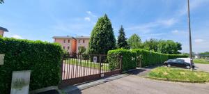 a fence in front of a house with a car at Appartamento Arese-Rho Fiera Milano in Arese