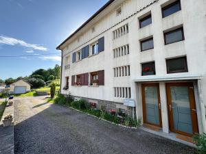 budynek z dwoma drzwiami i kwiatami przed nim w obiekcie Le Célesthémy w mieście Cornimont +7 zdjęć