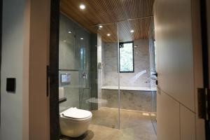 a bathroom with a toilet and a shower and a tub at Bhumiputra stays in Pernem