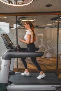 a woman running on a treadmill in a gym at Hotel Wagnerhof in Pertisau +141 photos