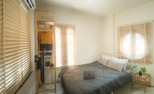 a bedroom with a bed with a laptop on it at Uncle NID Hostel in Lat Krabang