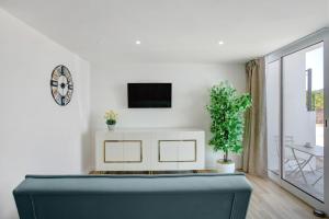 GaulaにあるStudio Casa Belavistaのソファと壁掛けテレビのあるリビングルーム