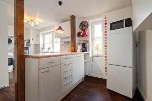 Una cocina con gabinetes blancos y un refrigerador blanco. en Rose, en Burg auf Fehmarn