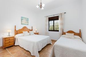 a bedroom with two beds and a window at El Mirador del Abuelo in Málaga +12 photos