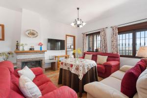 a living room with a red couch and a table at El Mirador del Abuelo in Málaga