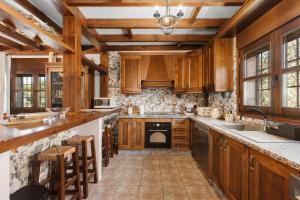 a kitchen with wooden cabinets and a stove top oven at Cortijo Era del Realenguillo in Villanueva de la Concepción