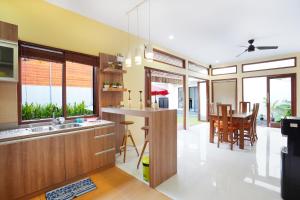a kitchen and dining room with a table and chairs at Mahabrahma Villa in Uluwatu