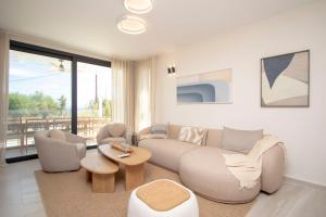a living room with a couch and chairs and a table at Daroma Villa, Paliouri by Halkidiki Villas in Paliouri