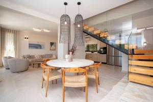 a dining room and living room with a table and chairs at Daroma Villa, Paliouri by Halkidiki Villas in Paliouri