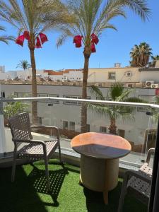 a balcony with palm trees and a table and chairs at Domi Chalet in Hurghada +2 photos