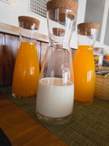 three bottles of milk and orange juice on a counter at AL Moniz in Machico +30 photos