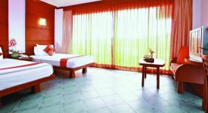 ein Hotelzimmer mit 2 Betten, einem Schreibtisch und einem TV in der Unterkunft Hua Hin Loft in Hua Hin