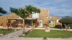 dom z drzewem przed nim w obiekcie Logis hôtel restaurant Le clos saint loup w mieście Bram