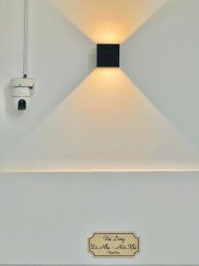 ein Licht hängt an einer Decke mit einem Schild drauf in der Unterkunft Hà Lan Homestay - GrandWorld in Phu Quoc