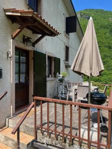 a patio with an umbrella next to a building at Haus Granata Family - Trekking - Bike in Giazza