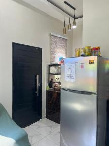 a kitchen with a refrigerator and a black door at Homestay Armandz 3 bedrooms house in Masjid Tanah