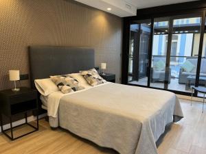 a bedroom with a large bed and a balcony at Apartamentos Romero in Alicante