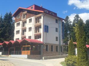 a large white building with a red roof at The Lodge Hotel in Borovets