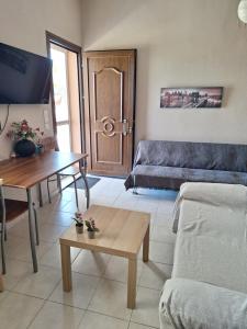 a living room with a couch and a table at Ioanna's house in Agios Georgios