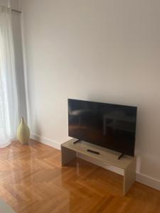 a flat screen tv sitting on a stand in a living room at Neapoli Modern Apartment in Athens