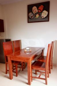 a wooden dining room table with chairs and a picture at Natha Ubud Villa in Ubud