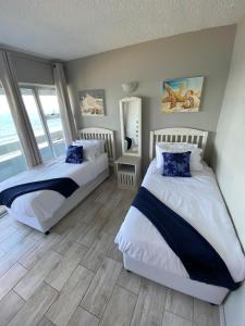 ダーバンにある138 Stella Maris, 73 Beach Road, Amanzimtoti Durban South Africaのベッドルーム1室(青い枕のベッド2台付)