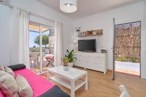 a living room with a couch and a tv and a table at Casa Rural El Granado in Nerja