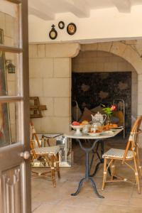 a table and chairs in a room with a fireplace at Manoir saint Eusèbe in Gennes +30 photos