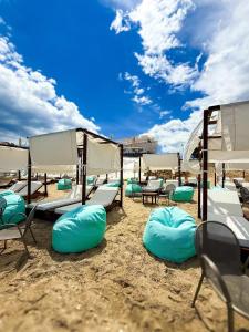 a group of chairs and umbrellas on a beach at Angelo Apartments in Paralía Avdhíron